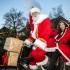 Weihnachtsmann auf dem Fahrrad mit Paketen und Weihnachtsfrau auf dem Gepäckträger