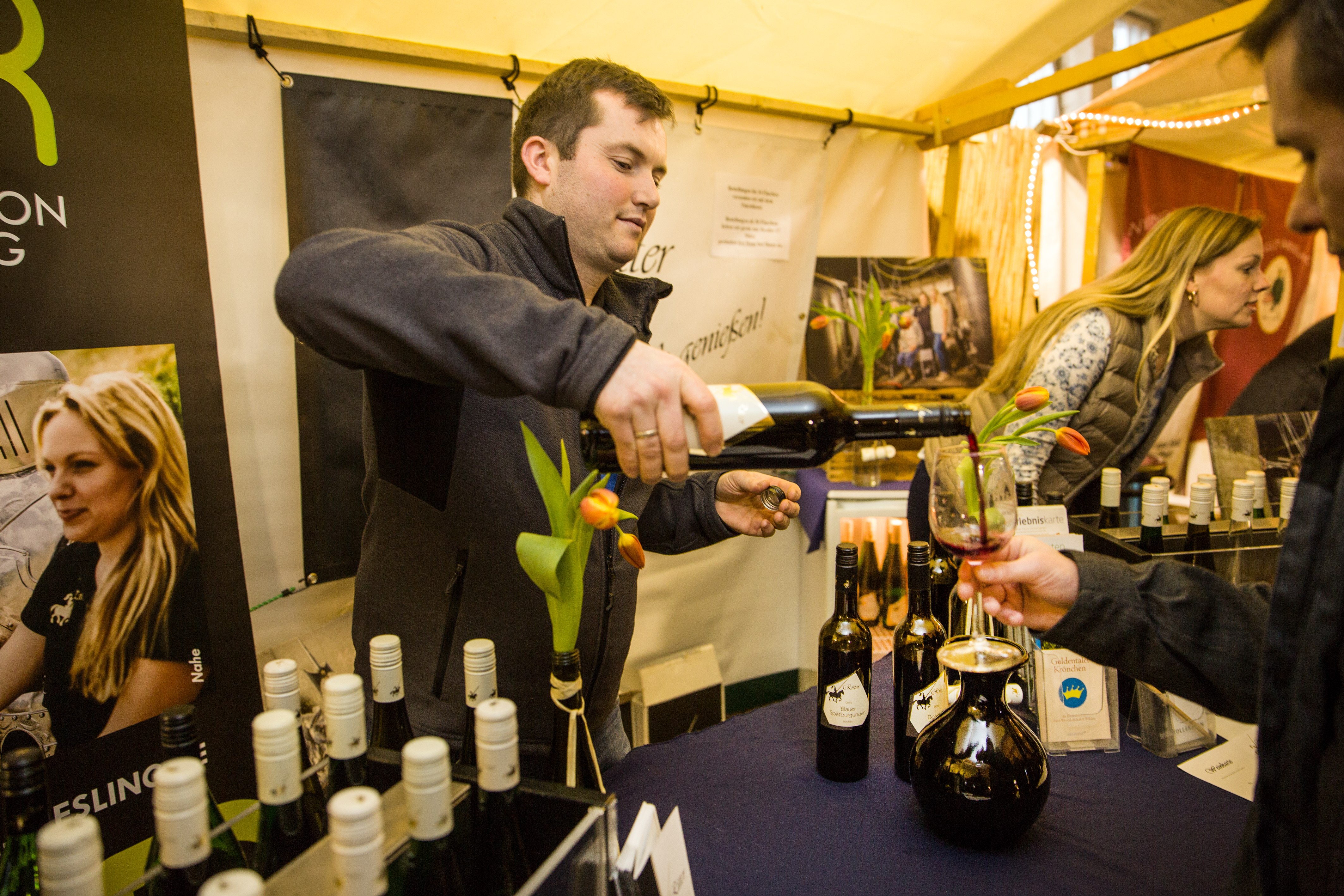 Winzer Ritter von der Nahe schenkt einem Gast Rotwein ein