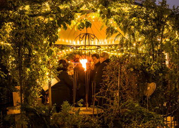 Kräutergarten im Advent mit Tannenzweigen und Fackel