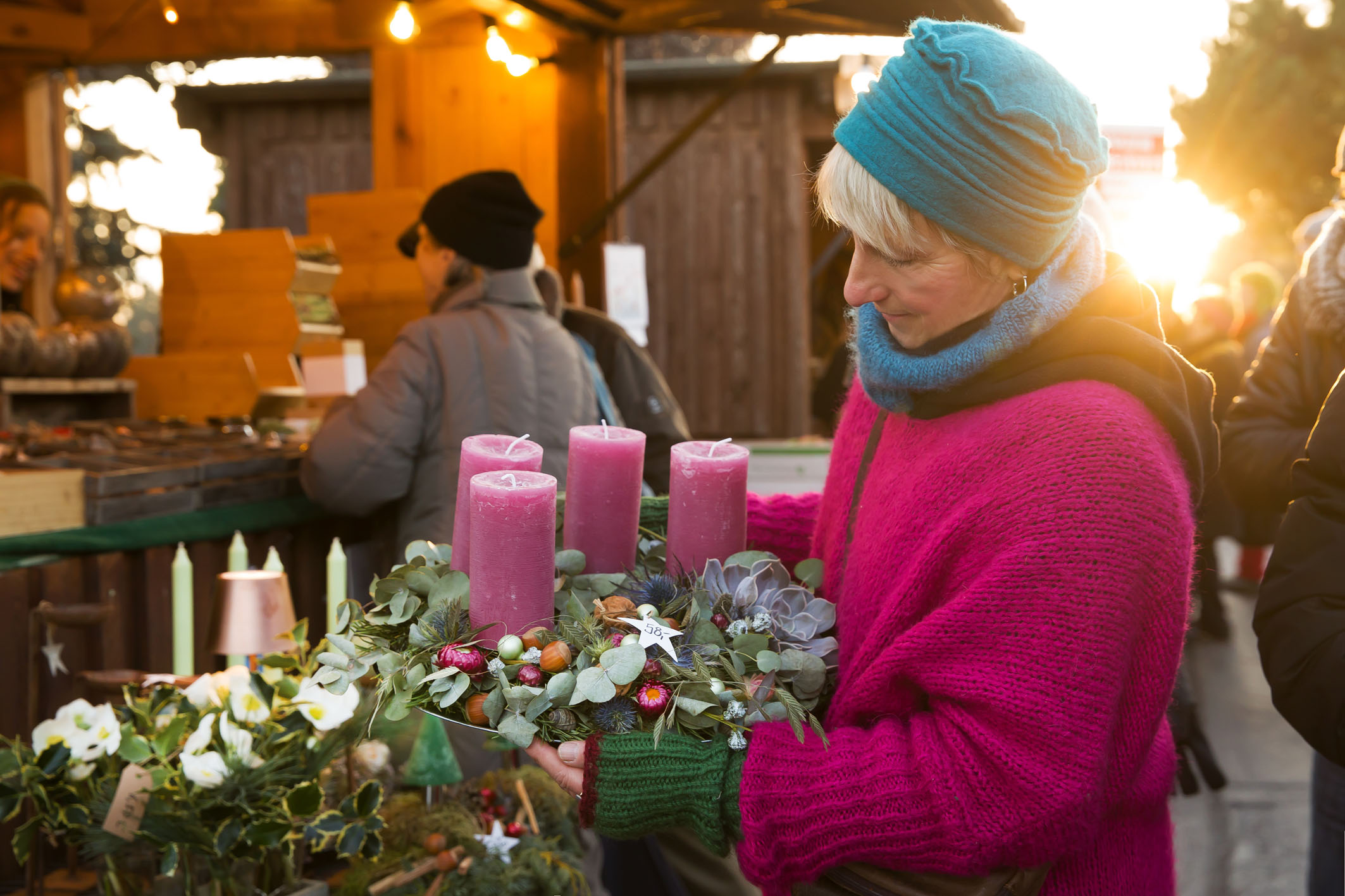 Besucherin betrachtet liebevoll einen Adventskranz