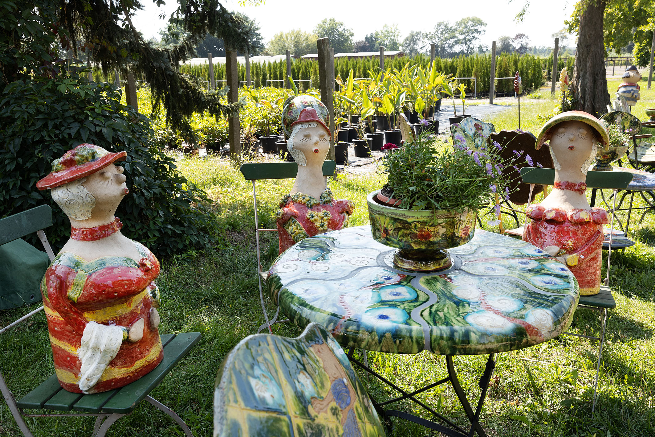 Gartenkeramik: Figuren und Gartenmöbel, im Hintergrund: Pflanzen-Produktionsflächen von Späth