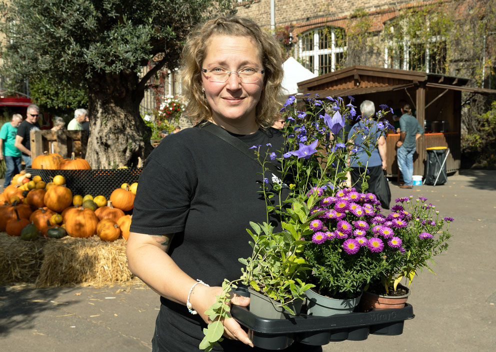 Susanne Schmohl, eine der drei Späth-Geschäftsführerinnen, beim Traditionsfest auf dem Späth-Hof mit blühenden Stauden in der Hand, Foto: Daniela Incoronato